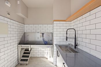 A kitchen with a sink and a stainless steel counter.